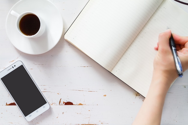 Bloc-notes téléphone et petit déjeuner, fond de bois blanc