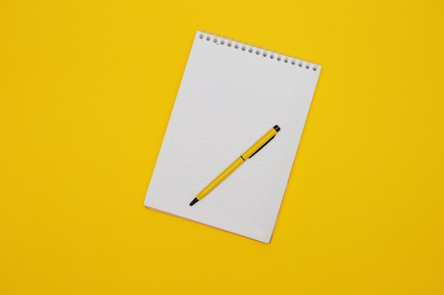 Photo bloc-notes vide sur jaune avec un stylo jaune.