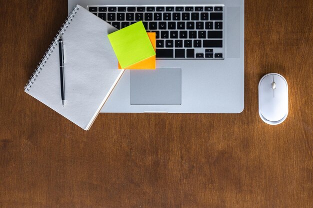 Un bloc-notes vide d'un ordinateur portable et une souris d'ordinateur sur une table en bois