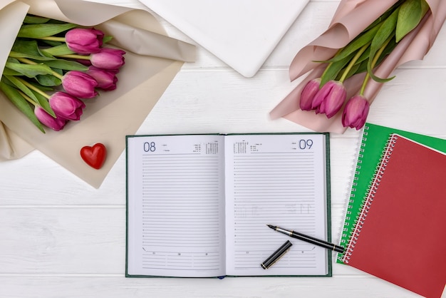 Bloc-notes vierge avec des tulipes sur table en bois