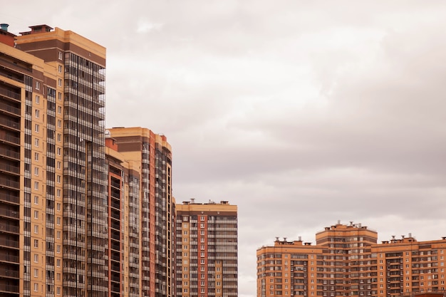 Bloc résidentiel moderne d'immeubles d'appartements avec façade d'immeubles plats contre un ciel bleu clair. Immobilier urbain et complexe de bâtiments pour les personnes. Concept de rénovation de logement. Espace de copie