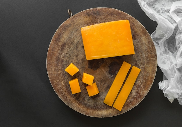 Bloc, tranches et cubes de fromage cheddar