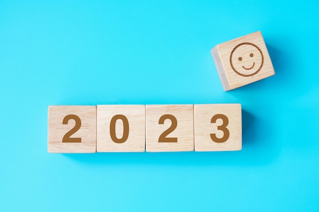 Bloc de visage souriant avec texte 2023 sur fond bleu Commentaires de satisfaction Examen et concepts du Nouvel An