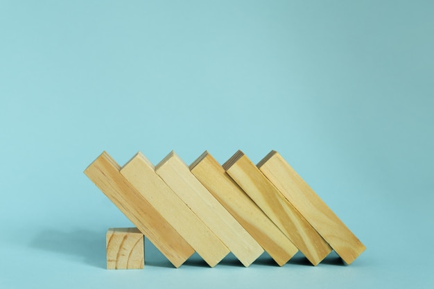 Blocs en bois sur fond bleu. effet domino dans le concept d'entreprise.