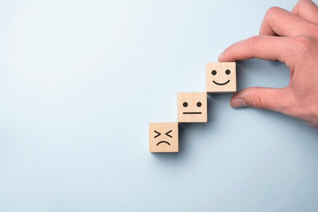 Blocs en bois avec le symbole de symbole de visage de sourire de visage heureux sur la table