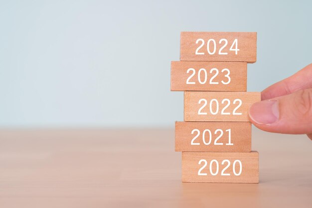 Blocs en bois avec texte de concept 2022 et une main humaine.