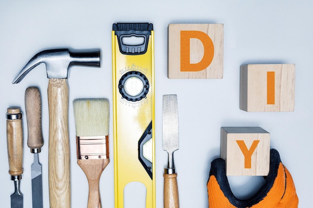 Blocs de cube en bois avec des lettres DIY et différents outils sur une surface gris clair Concept DIY