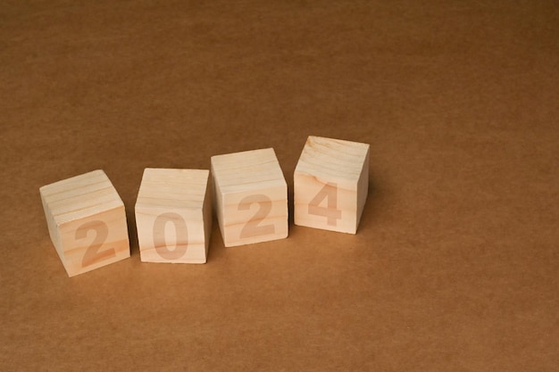 Blocs de cube en bois avec le texte 2024 sur fond brun Commencez la nouvelle année et le concept de vision d'entreprise