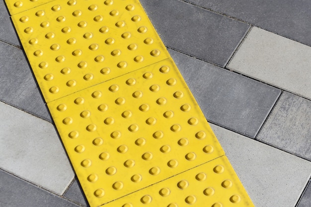 Blocs jaunes de pavage tactile pour handicap aveugle. Blocs en braille, tuiles tactiles pour les malvoyants, blocs Tenji