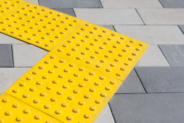 Blocs jaunes de pavage tactile pour handicap aveugle. Blocs en braille, tuiles tactiles pour les malvoyants, blocs Tenji