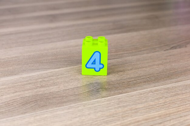 Blocs de jouets formant un cube avec le numéro quatre isolé sur fond blanc