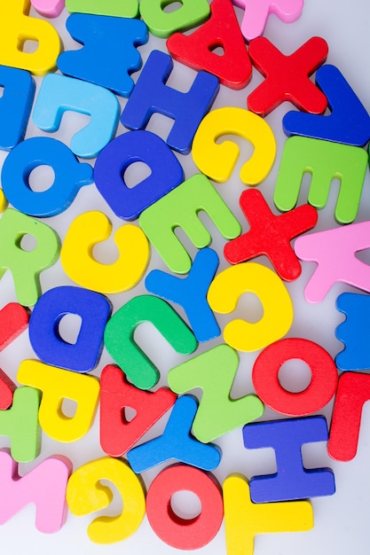 Blocs de lettres alphabet coloré dispersés au hasard sur fond blanc