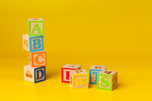 Blocs de surface en bois colorés avec des lettres de couleur jaune