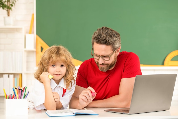 Blog familial enfance et parentalité petit garçon étude avec enseignant privé webinaire leçon vidéo éducation en ligne sur ordinateur portable père et fils utilisent les technologies de communication modernes