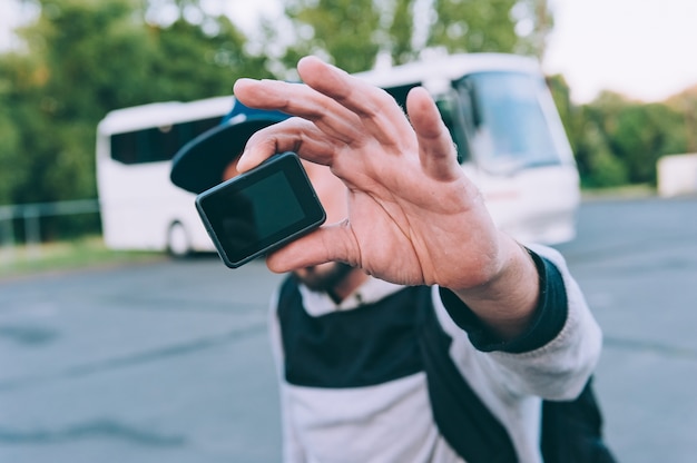 Blogger avec une caméra d'action dans ses mains, contre l'espace d'un bus.