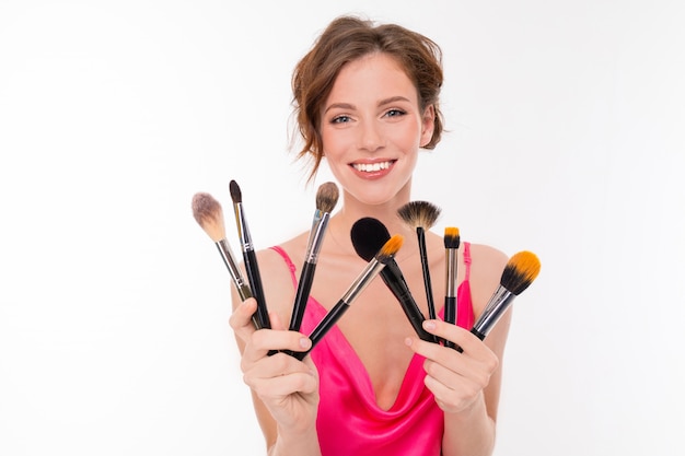 Blogger girl avec des pinceaux de maquillage sur une surface isolée blanche