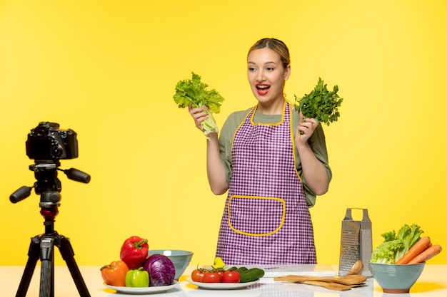 Blogueur culinaire adorable chef en bonne santé enregistrant une vidéo pour les médias sociaux avec du persil heureux