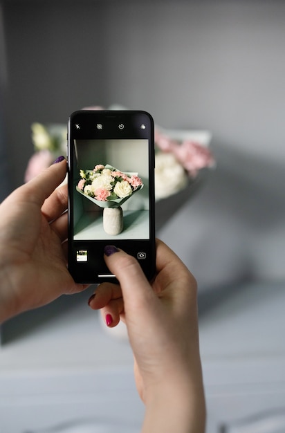 Un blogueur prend une photo d'un bouquet de fleurs