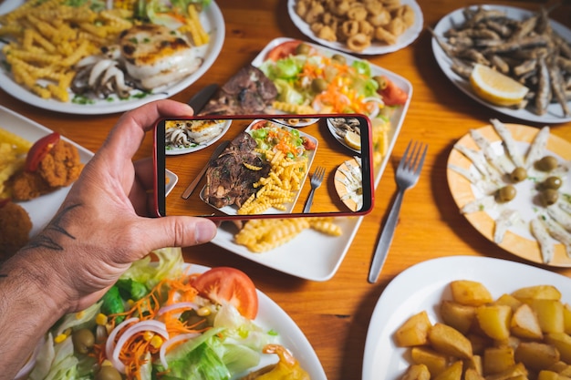 Le blogueur prend une photo des plats sur la table du restaurant