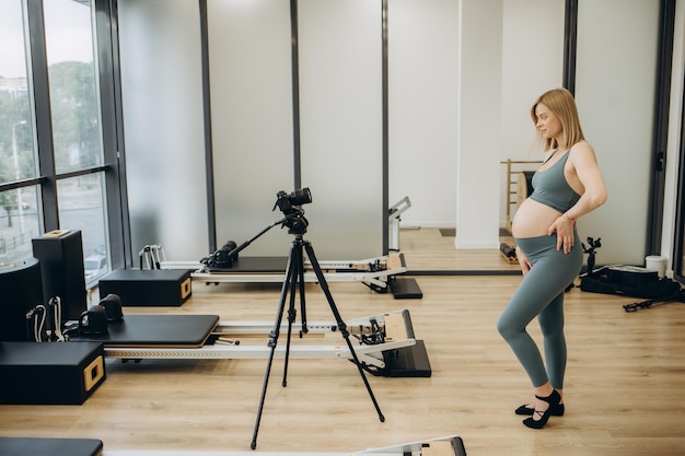 Blogueur sportif Une belle femme enceinte fait du sport et tourne une séance d'entraînement sur la vidéo de l'appareil photo Santé et sport pendant la grossesse Photo de haute qualité
