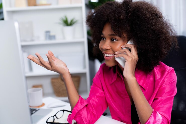 Photo une blogueuse africaine en train de parler au téléphone avec un collègue ou un ami.