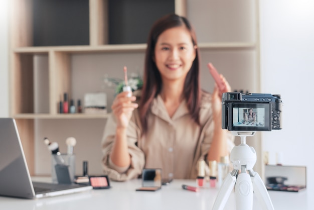 Blogueuse beauté enregistrant une vidéo et présentant des cosmétiques à la maison