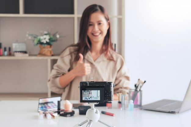 Blogueuse beauté enregistrant une vidéo et présentant des cosmétiques à la maison