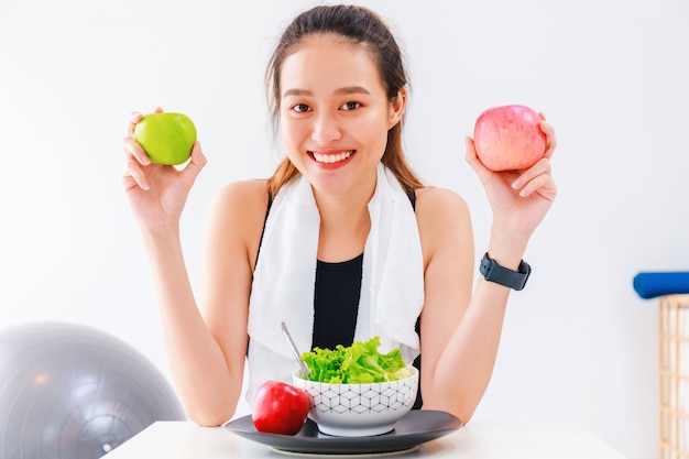 Une blogueuse en bonne santé de belle femme asiatique montre des fruits et des aliments diététiques propres devant la caméra pour enregistrer une vidéo vlog en direct à la maison.