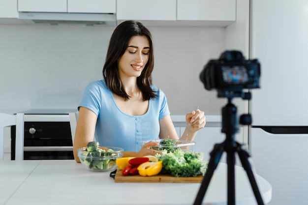 Une blogueuse culinaire enregistre une vidéo à la maison dans la cuisine en parlant de mode de vie sain et de nourriture