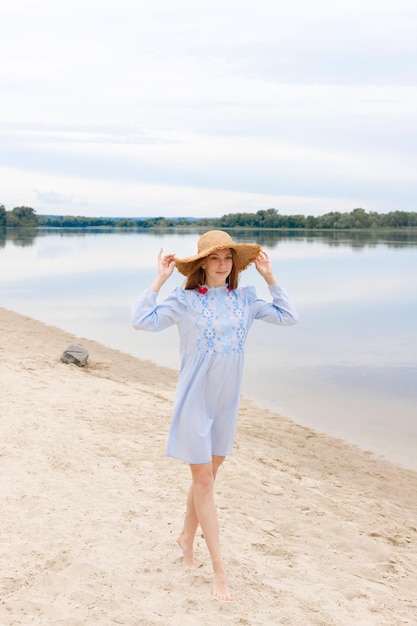 Une blogueuse dans un chapeau de paille sur les vacances d'été à la plage
