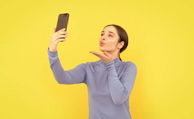 Une blogueuse utilise un appel vidéo sur smartphone vlog en ligne avec un baiser sur un téléphone portable