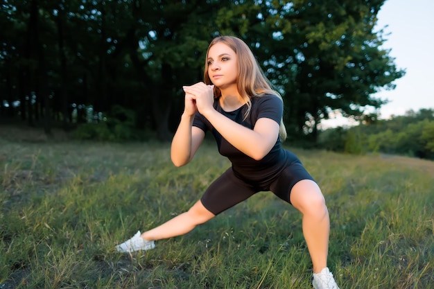 Blonde athlétique avec une silhouette mince effectue des exercices de force pour les squats