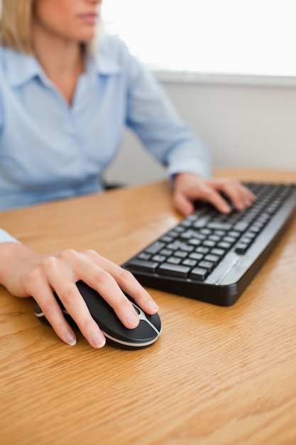 Blonde femme d&#39;affaires avec les mains sur la souris et le clavier