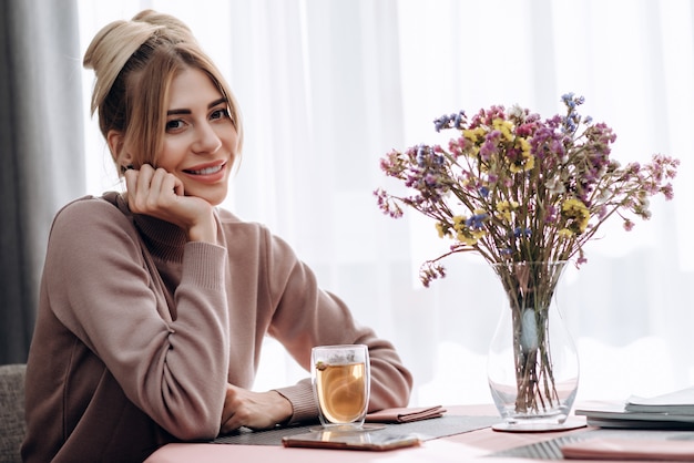 Blonde femme souriante est assise dans un café