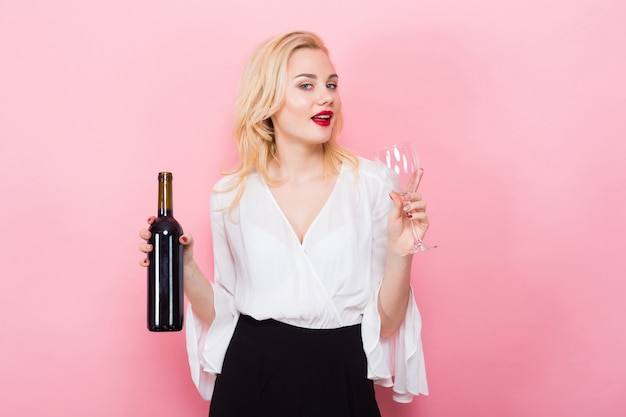 Blonde femme tenant une bouteille de vin et un verre