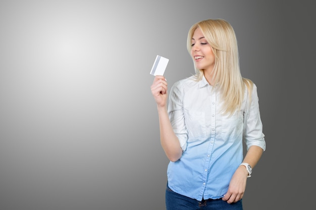 Blonde femme tenant une carte de crédit