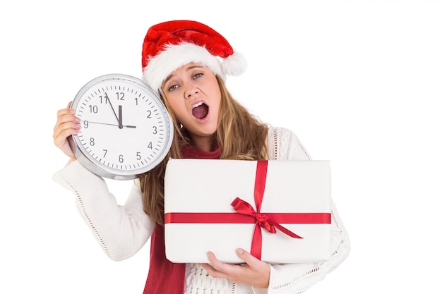 Blonde festive montrant une horloge et un cadeau