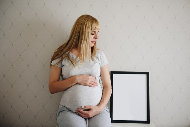 Blonde fille enceinte à la maison