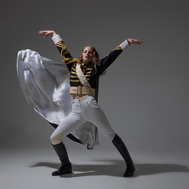 Une blonde glamour dans un uniforme de carnaval avec des épaulettes posant avec des poses prétentieuses un animateur de spectacle o