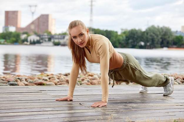 Blonde jeune femme athlétique travaillant dans un parc en milieu urbain Jolie femme athlétique exerçant à l'extérieur le matin copie espace Concept de remise en forme santé