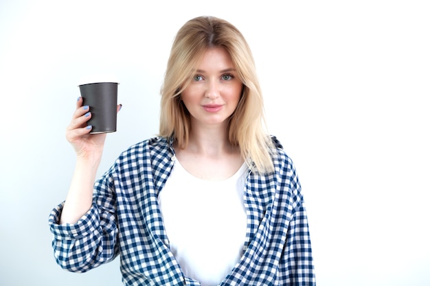 Blonde jeune femme en chemise décontractée tenant une tasse de café noir