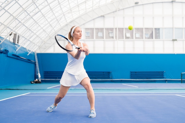 Blonde jeune femme jouant au tennis