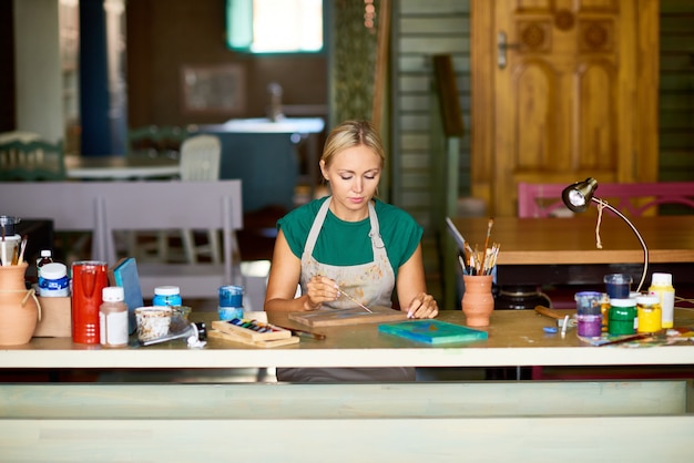 Blonde jeune femme peinture dans Art Studio