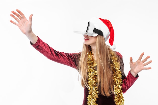 Blonde jeune femme portant un bonnet de Noel et casque VR