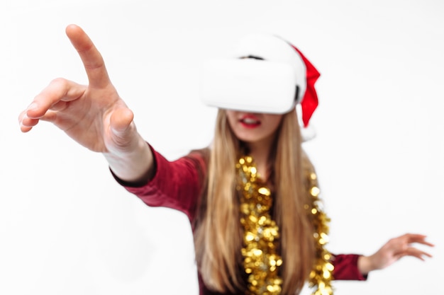 Blonde jeune femme portant un bonnet de Noel et casque VR