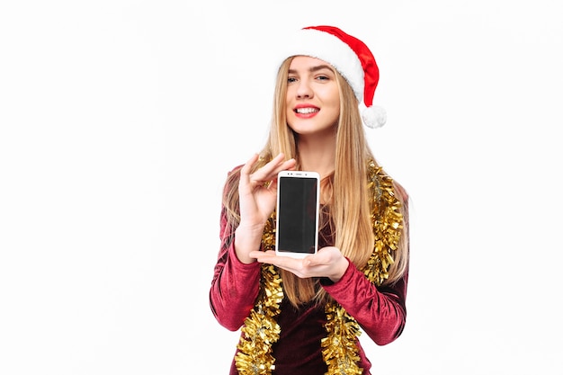 Blonde jeune femme portant un bonnet de Noel et des guirlandes