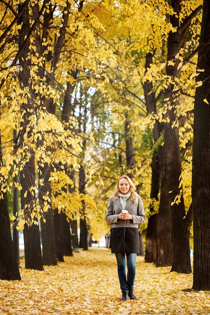 Photo blonde jolie femme marchant dans la nature en automne bon concept de journée active