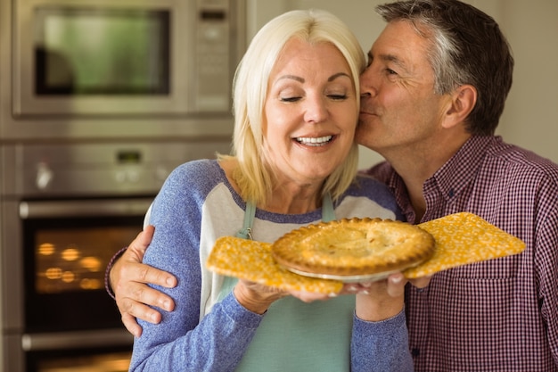 Blonde mature tenant une tarte fraîche avec son mari l&#39;embrassant
