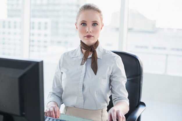 Blonde poupe femme d&#39;affaires assis au bureau