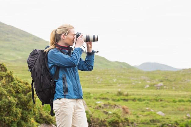 Blonde sur une randonnée en prenant une photo